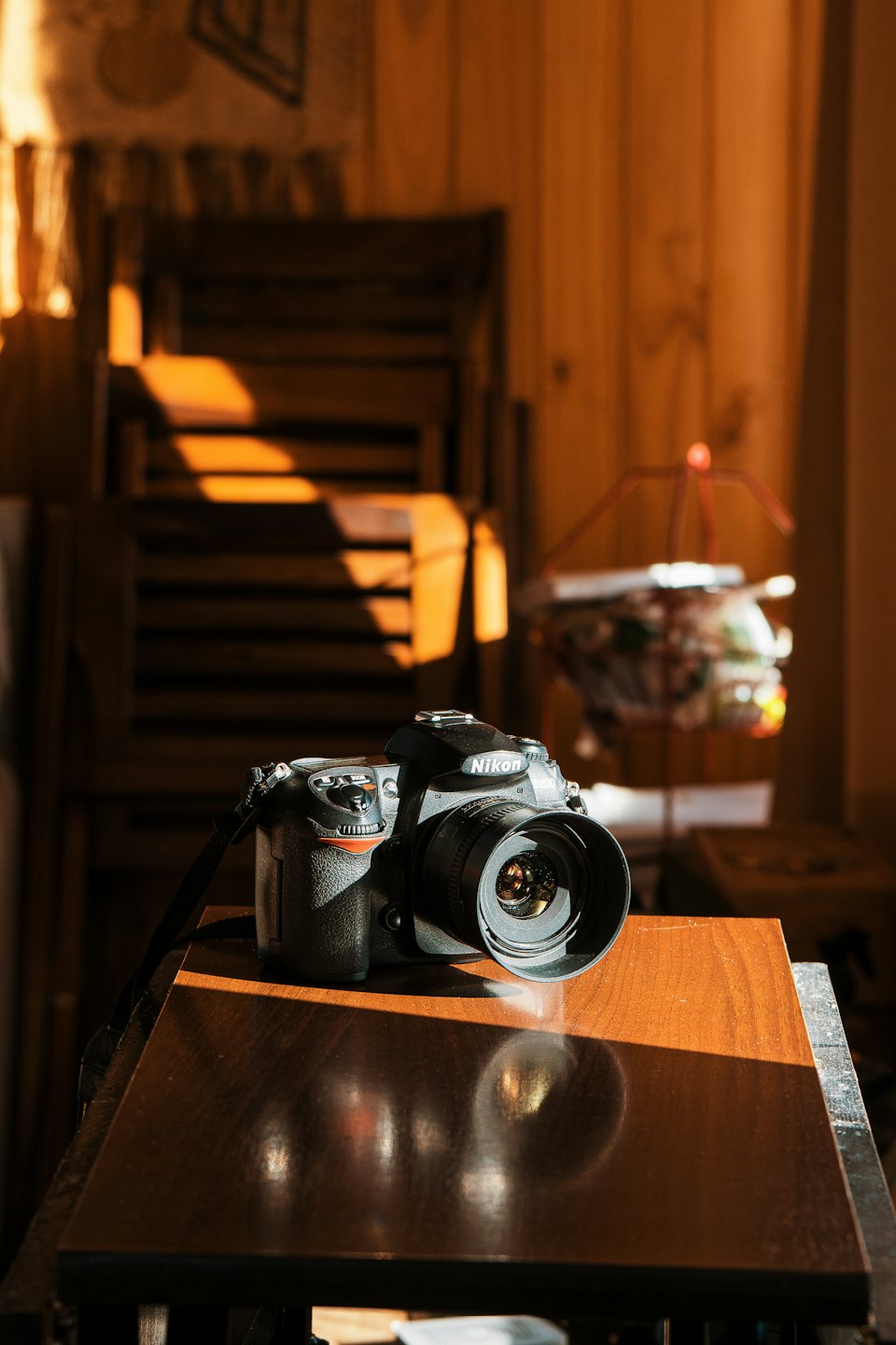 Schwarze DSLR-Kamera mit Objektiv auf einem Holztisch.