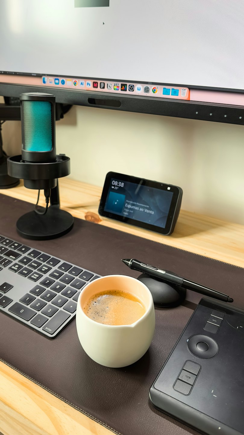 Moderner Computertisch mit Elektronik und einer Kaffeetasse.